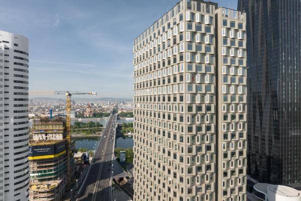Luftaufnahme von Näherem. Der Tower steht im Zentrum und im Hintergrund ist die Donau zu sehen. Rechts der DC Tower 1. Oben auf dem Gebäude ist die Dachterrasse zu sehen. Luftaufnahme von Näherem. Der Tower steht im Zentrum und im Hintergrund ist die Donau zu sehen. Rechts der DC Tower 1. Oben auf dem Gebäude ist die Dachterrasse zu sehen.
