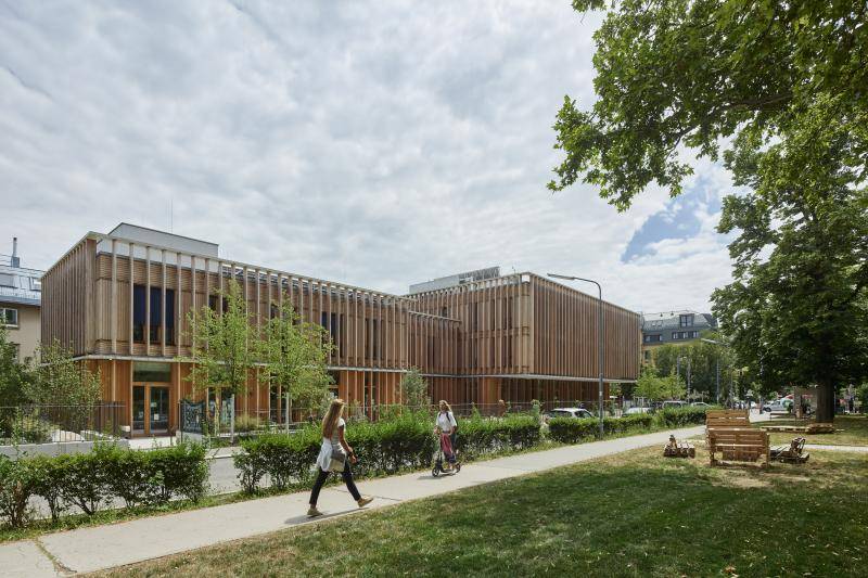Direkt neben dem Gebäude befindet sich ein Park. Die natürliche Holzfassade fügt sich in das Gesamtbild ein. Direkt neben dem Gebäude befindet sich ein Park. Die natürliche Holzfassade fügt sich in das Gesamtbild ein.