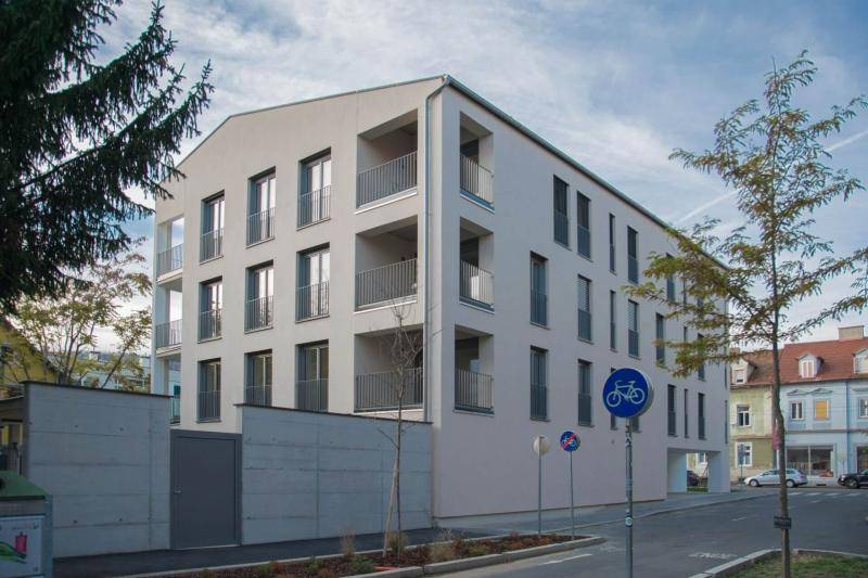 Das Gebäude in voller größe mit weißer Putzfassade, ohne Dachüberstände und zahlreichen, versetzten Fenstern an der längsseite. Das Gebäude in voller größe mit weißer Putzfassade, ohne Dachüberstände und zahlreichen, versetzten Fenstern an der längsseite.