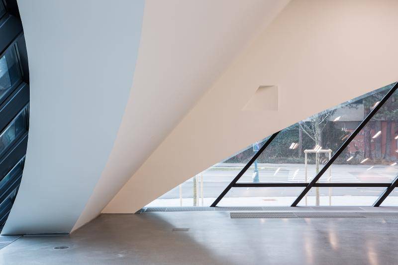 Zu sehen ist eine Innenaufnahme einer der Gebäudeecken. Das massive Gebäudeeck steigt langsam schräg geneigt nach oben an. Rechts und links davon sind Fensterflächen zu sehen.