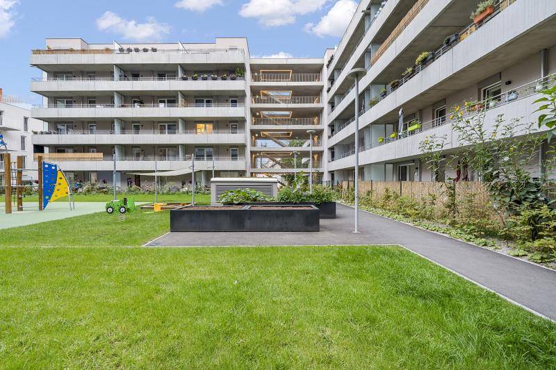 Blick in den Innenhof des U-Förmigen Gebäudes. Hier ist ein kleiner Spielplatz sowie Rasen und kleine Hochbeete angelegt. Blick in den Innenhof des U-Förmigen Gebäudes. Hier ist ein kleiner Spielplatz sowie Rasen und kleine Hochbeete angelegt.