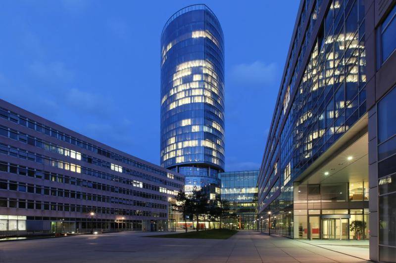 Der Turm im Eck des Gebäudekomplexes. Die Hälfte der Räume sind beleuchtet im Innern. Außen setzt die Dunkelheit ein. Der Turm im Eck des Gebäudekomplexes. Die Hälfte der Räume sind beleuchtet im Innern. Außen setzt die Dunkelheit ein.