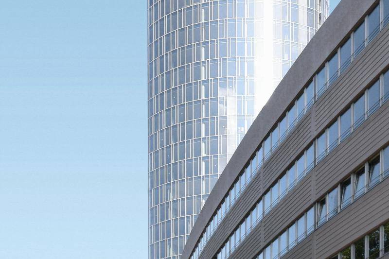 Der Glasturm ist zu sehen, wie er hinter einem anderen Gebäude aufsteigt. Sonne reflektiert in den Scheiben. Der Glasturm ist zu sehen, wie er hinter einem anderen Gebäude aufsteigt. Sonne reflektiert in den Scheiben.