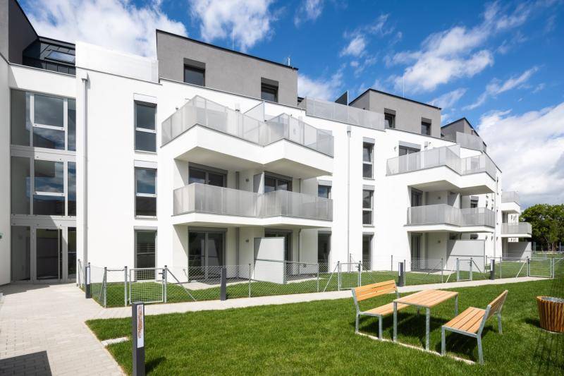 Auf der Rasenfläche vor dem Gebäude steht ein Picknick-Tisch mit Bänken aus Holz. Die EG Wohnungen haben eine kleine Terrasse, sowie eine eingezeunte Rasenfläche.