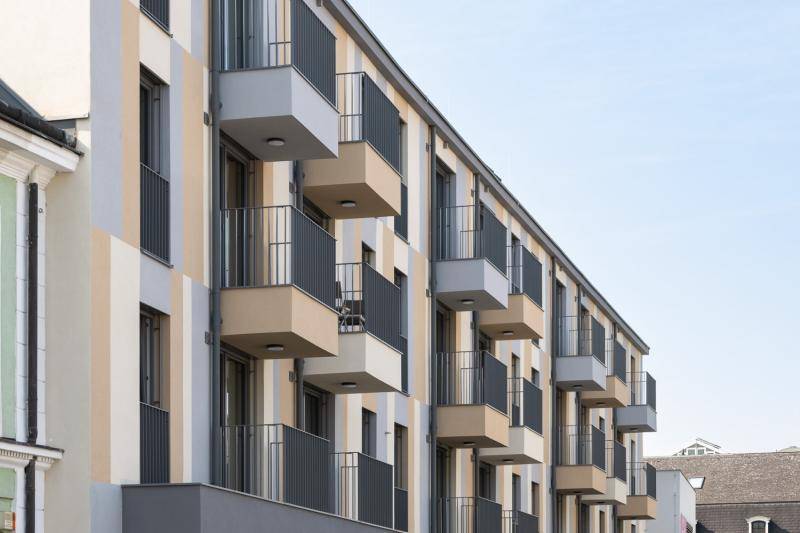 Im Erdgeschoss sind Ladengeschäfte angeordnet. Darübersind die Balkone der Wohnungen zu sehen. Im Erdgeschoss sind Ladengeschäfte angeordnet. Darübersind die Balkone der Wohnungen zu sehen.