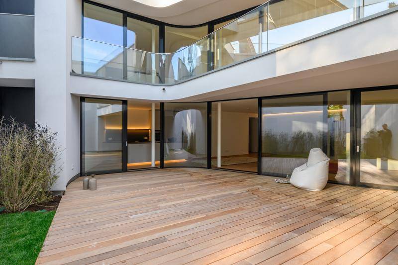 Große Holzterrasse vor einer Glasfront im Hinterhof des Gebäudes